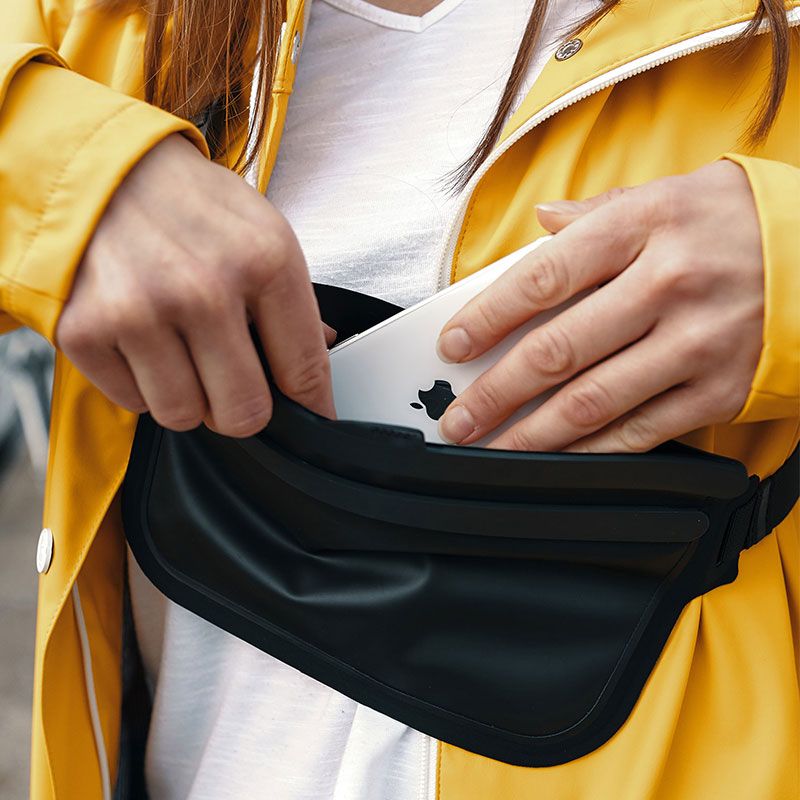 FIDLOCK-HERMETIC-sling-bag-schwarz-hände-die-ein.handy-reintun-outdoor_800x800