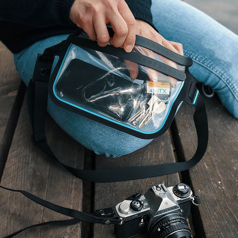 FIDLOCK-HERMETIC-sling-bag-transparent-outdoor-geöffnet-hand-holt-schlüssel-raus-photo-kontext_800x800
